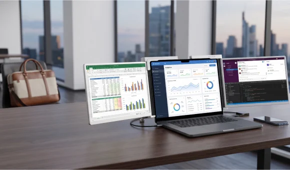 Laptop z dwoma przenośnymi monitorami na biurku, wyświetlający arkusz, analitykę i edytor kodu.